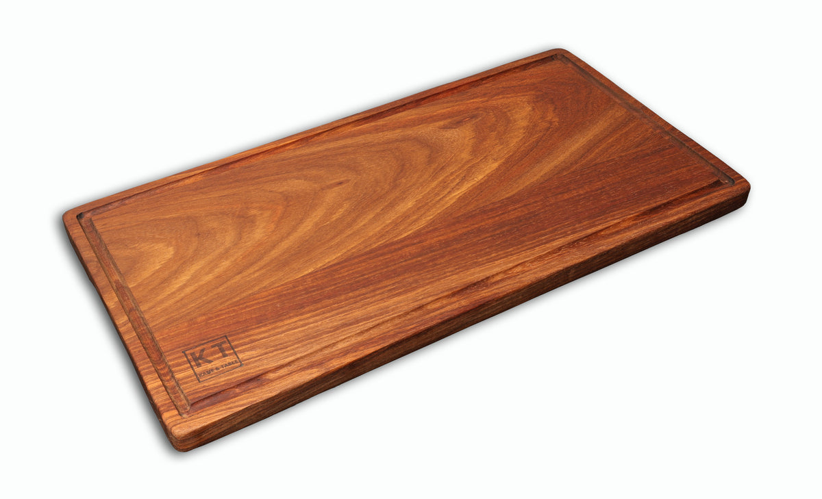 Large handcrafted wooden steak board with juice groove, shown at an angle